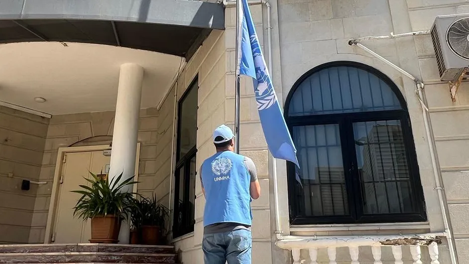 The United Nations flag is lowered at a UN building in Yemen. A UN staff is is lowering the UN flag at a UN building in Yemen