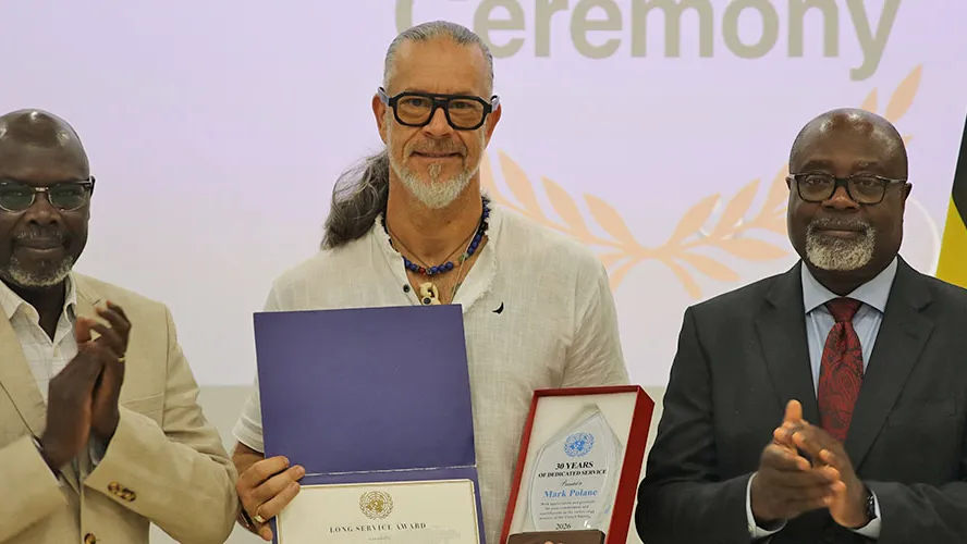 Mark Polane (c) shows his 30 year Long Service Awards presented to him by RSCE Director, Paulin Djomo (r) and Chief RFTS, Emmanuel Ngor (l) Chief RFTS, Emmanuel Ngor, Awardee Mark Polane and RSCE Director, Paulin Djomo