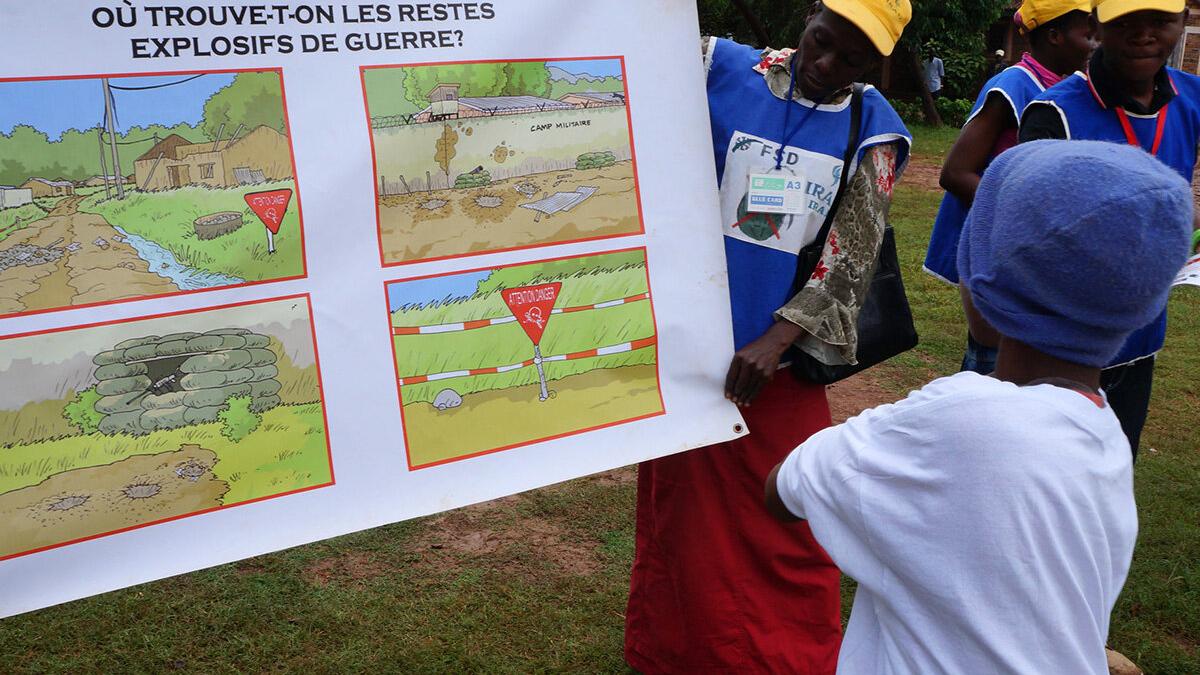 a woman is presenting a poster to a kid