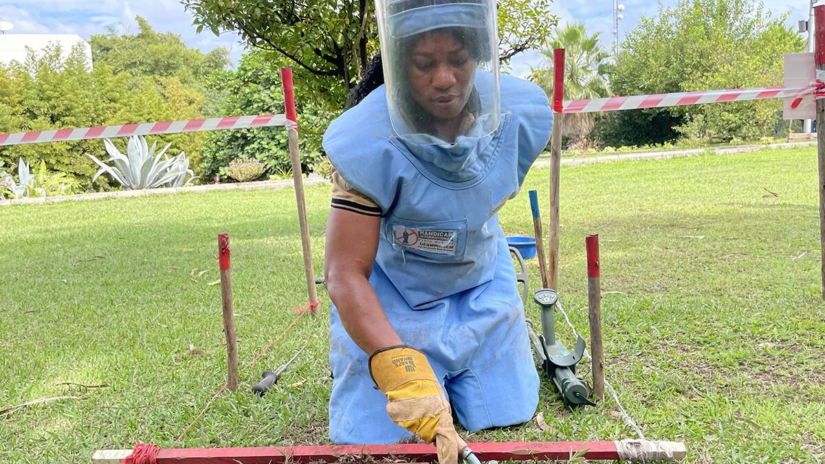 a female deminer is working in a field