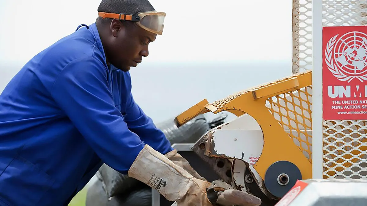 a man is destroying a weapon with a machine