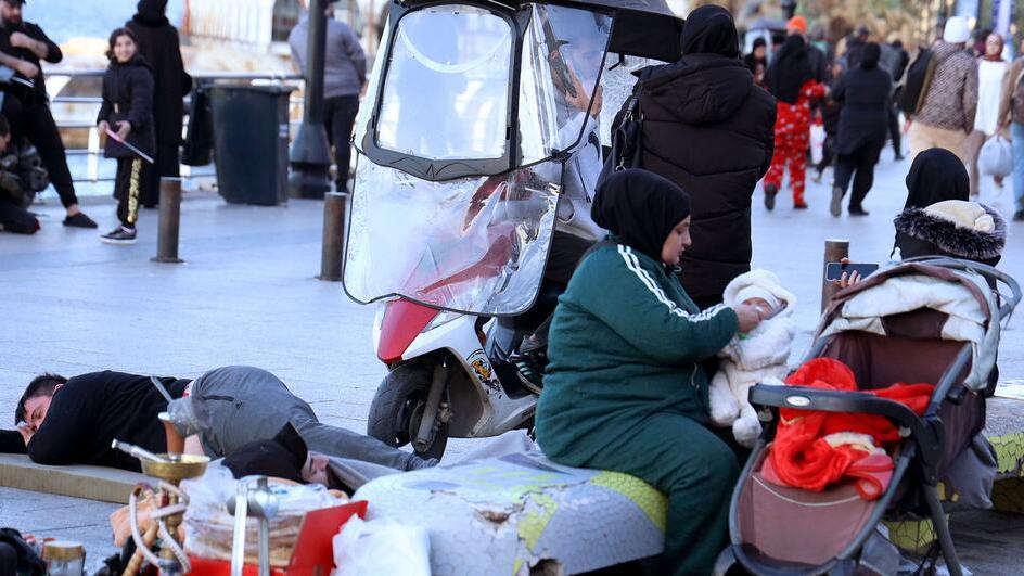© UNICEF/Dar al-Mussawir Family members rest on a street in Beirut, Lebanon, after fleeing their home following Israeli evacuation orders following Israeli evacuation orders