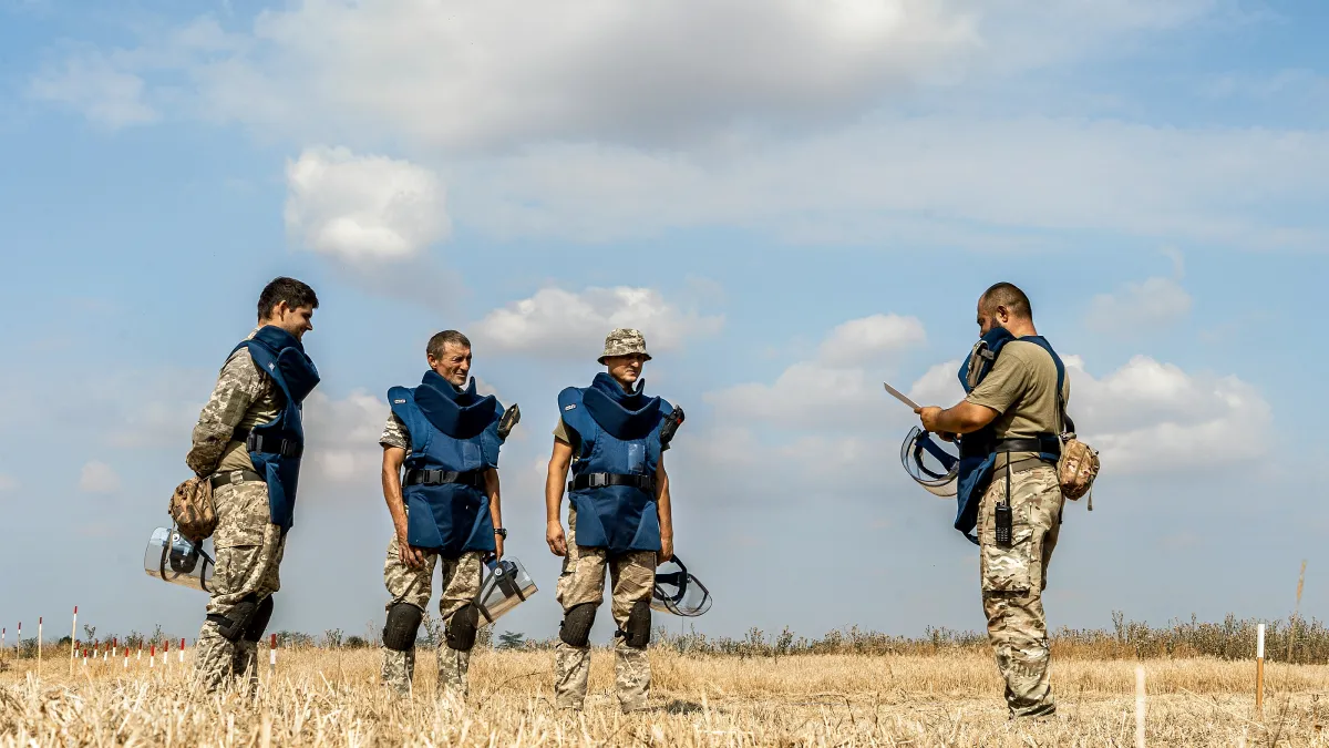 A group of SSTS deminers undergo a briefing before starting work on a potentially contaminated field in the Mykolaiv region. 