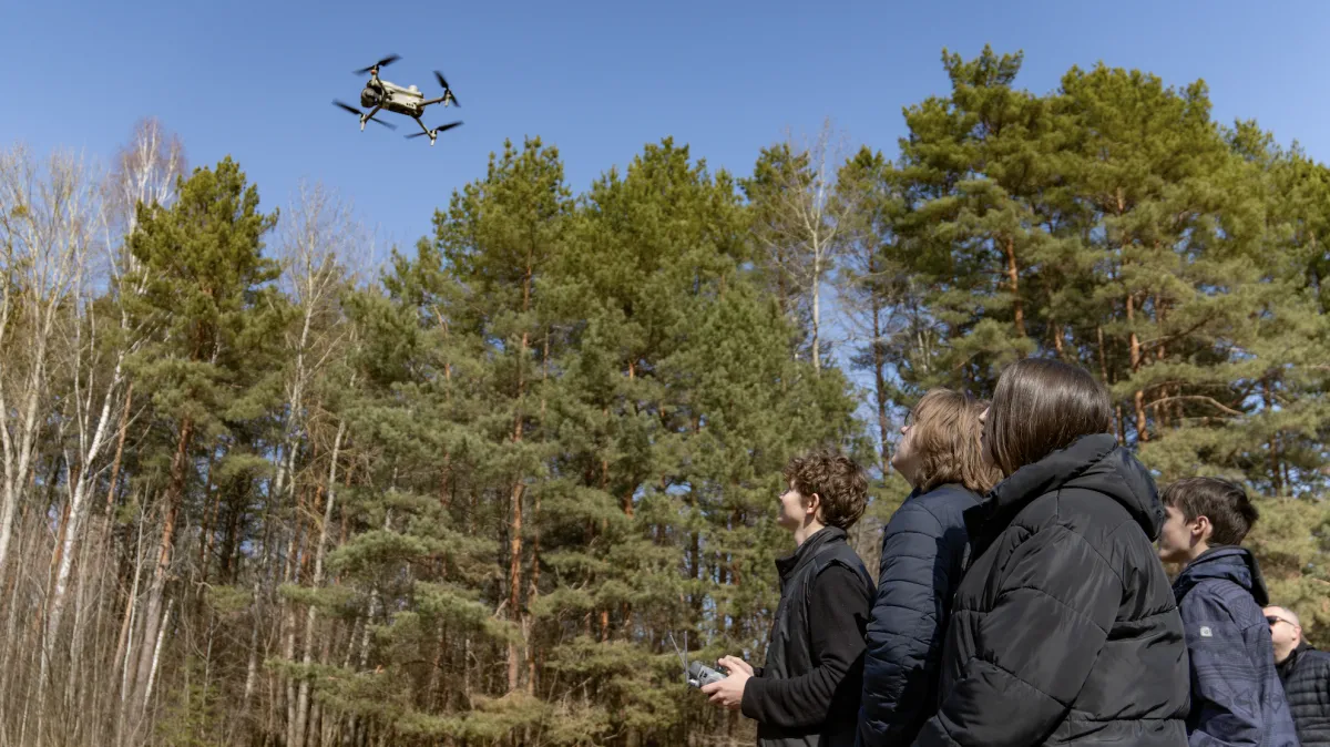 A group of second-year students practice operating a drone, procured and delivered by UNOPS 