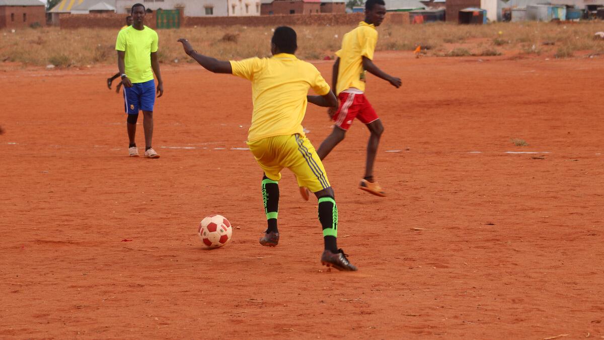 Youth playing football on a recently cleared parcel of land