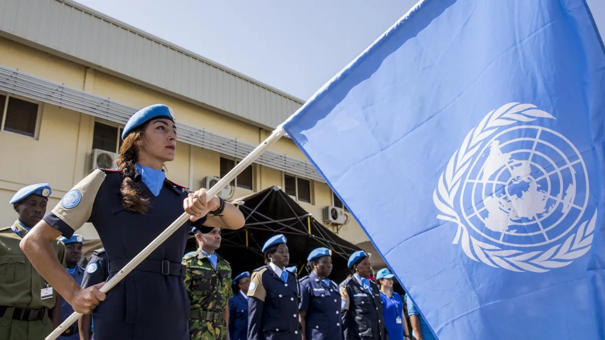 Un agent de police des Nations Unies tenant un drapeau des Nations Unies