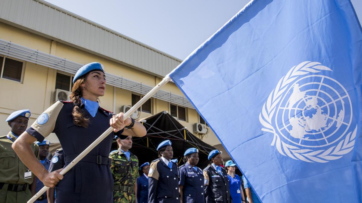 UN police officer holding un UN flag