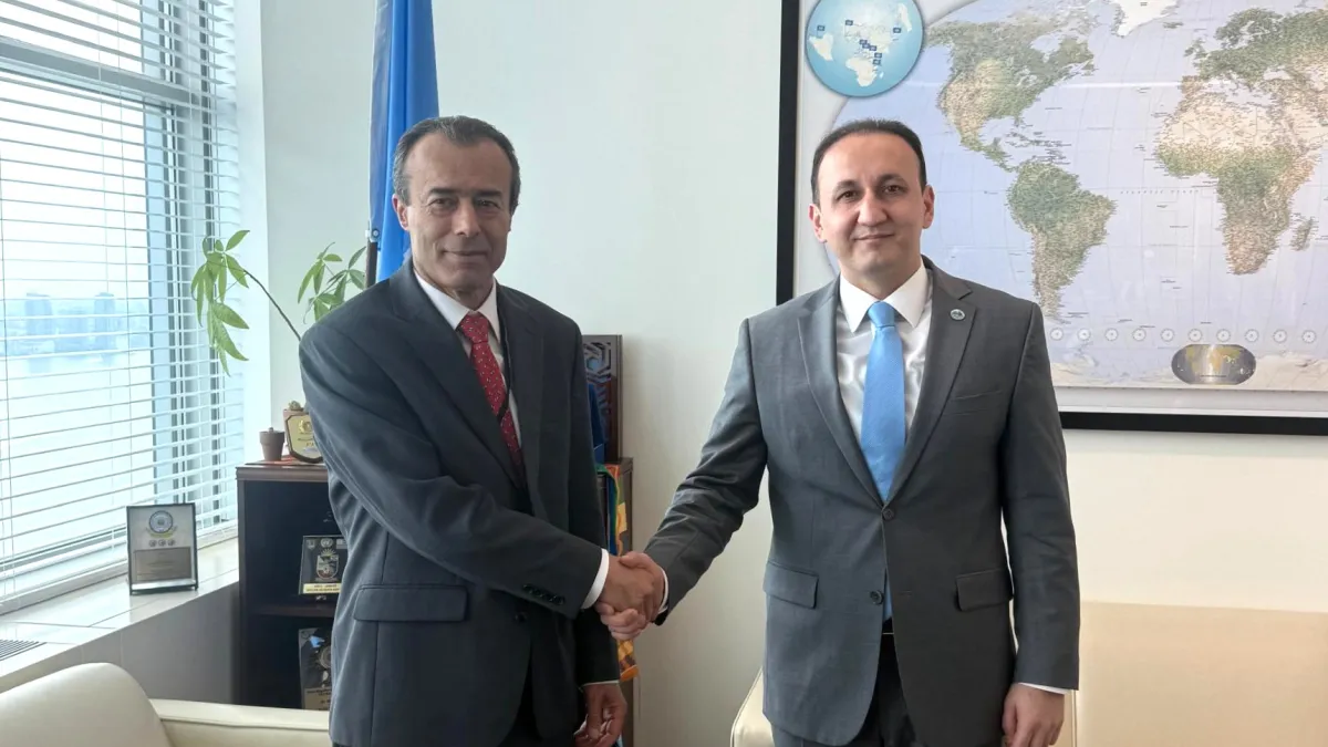 ASG Khaled Khiari and SCO Deputy Secretary-General Ahmad Saidmurodzoda shake hands.