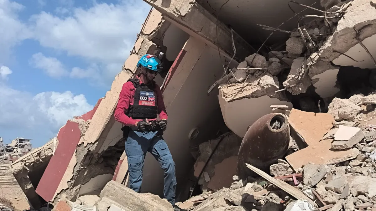 تقوم دائرة الأمم المتحدة للأعمال المتعلقة بالألغام (UNMAS) بتقييم جسم من الذخائر المتفجرة وسط الأنقاض أثناء عملية تقييم مخاطر في غزة. مايو 2026.