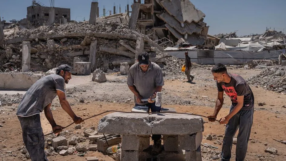 Three men begin the process of rebuilding their lives amidst the rubble of destroyed buildings in Jabalia, Gaza.