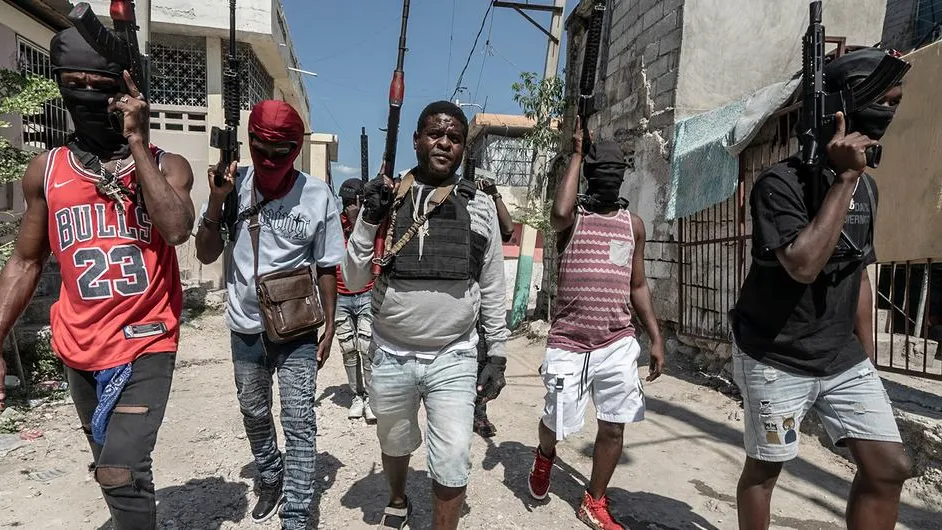 Gang members walk through a neighbourhood in Port-au-Prince.