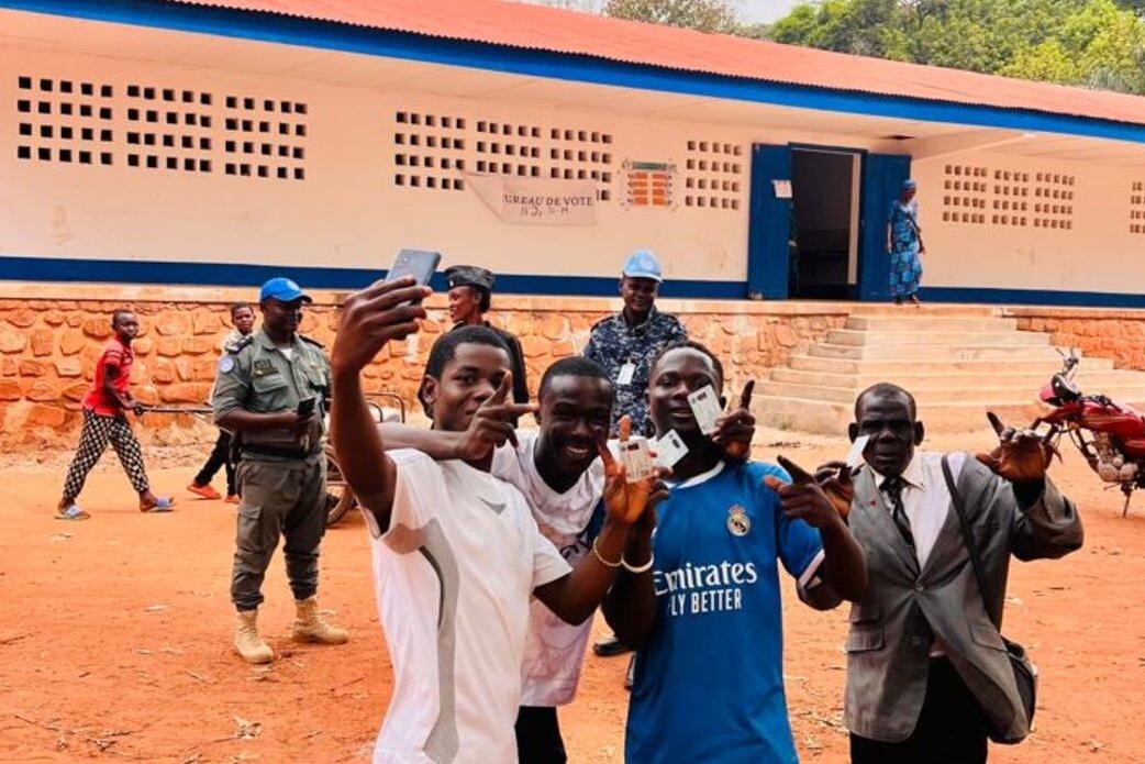 Un groupe de personnes prend une photo de groupe pour célébrer l'événement, en tenant leurs cartes d'identité.