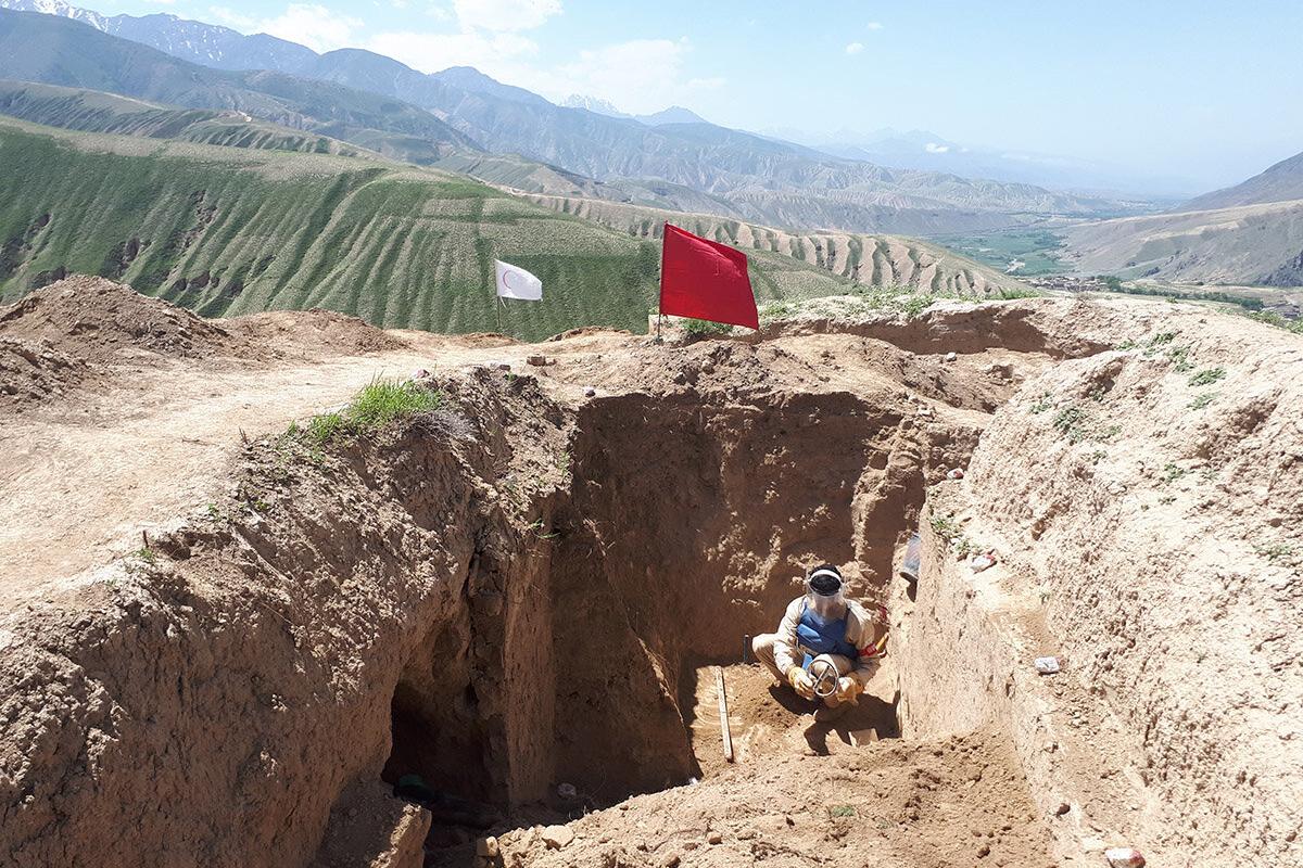 a deminer is clearing a field in a pit