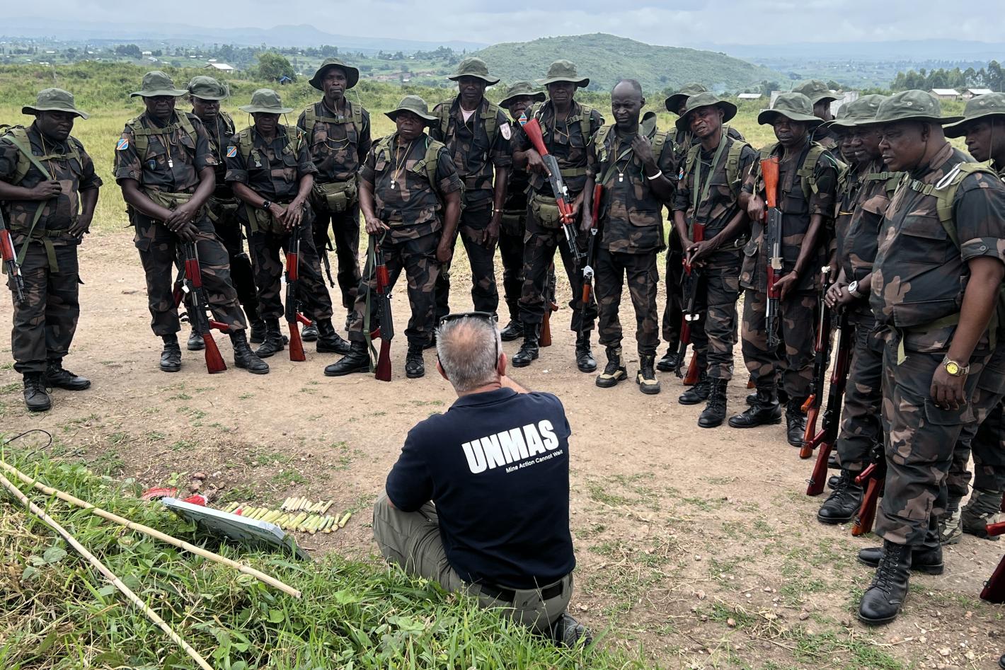 an unmas staff is showing something to a group of soldiers