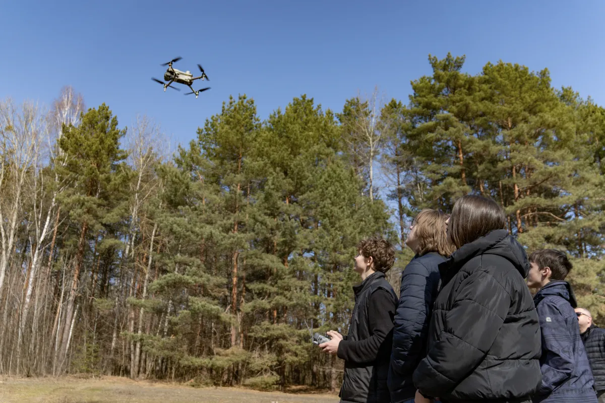 A group of second-year students practice operating a drone, procured and delivered by UNOPS 