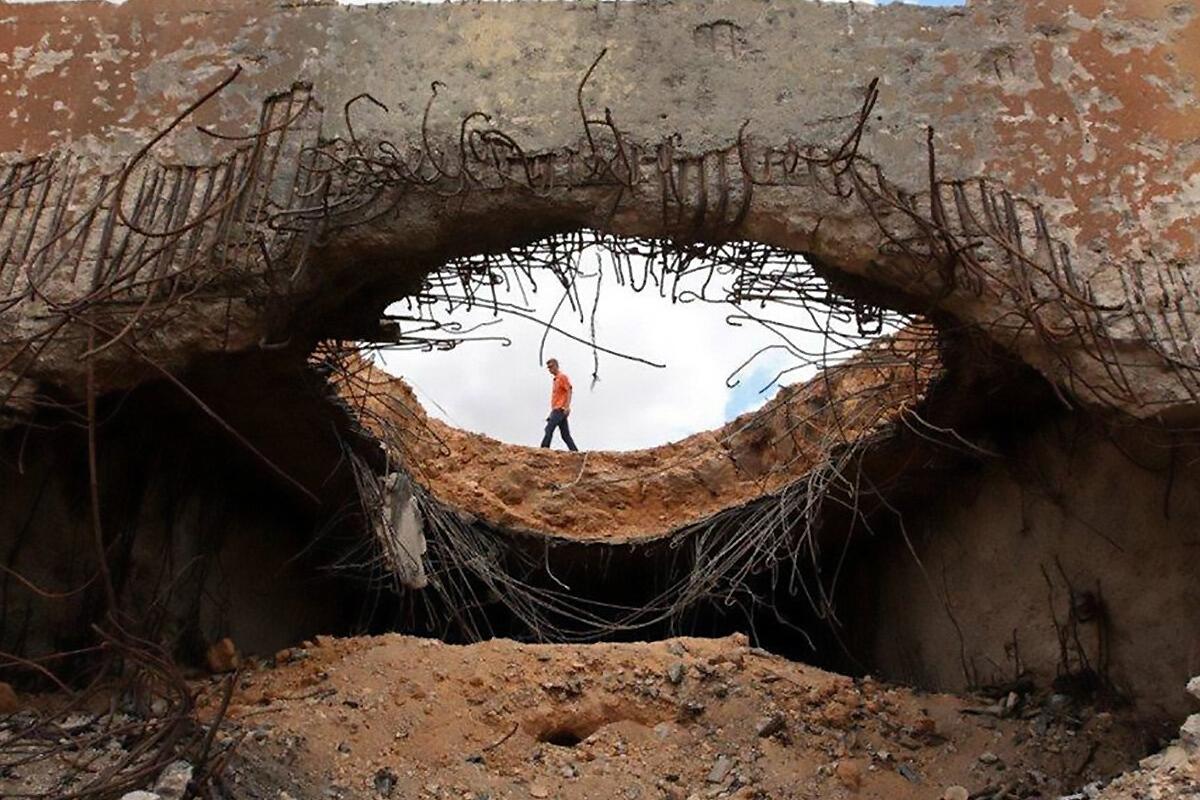 Mine action expert investigates a destroyed bunker within an ammunition storage area in Misrata, Libya.