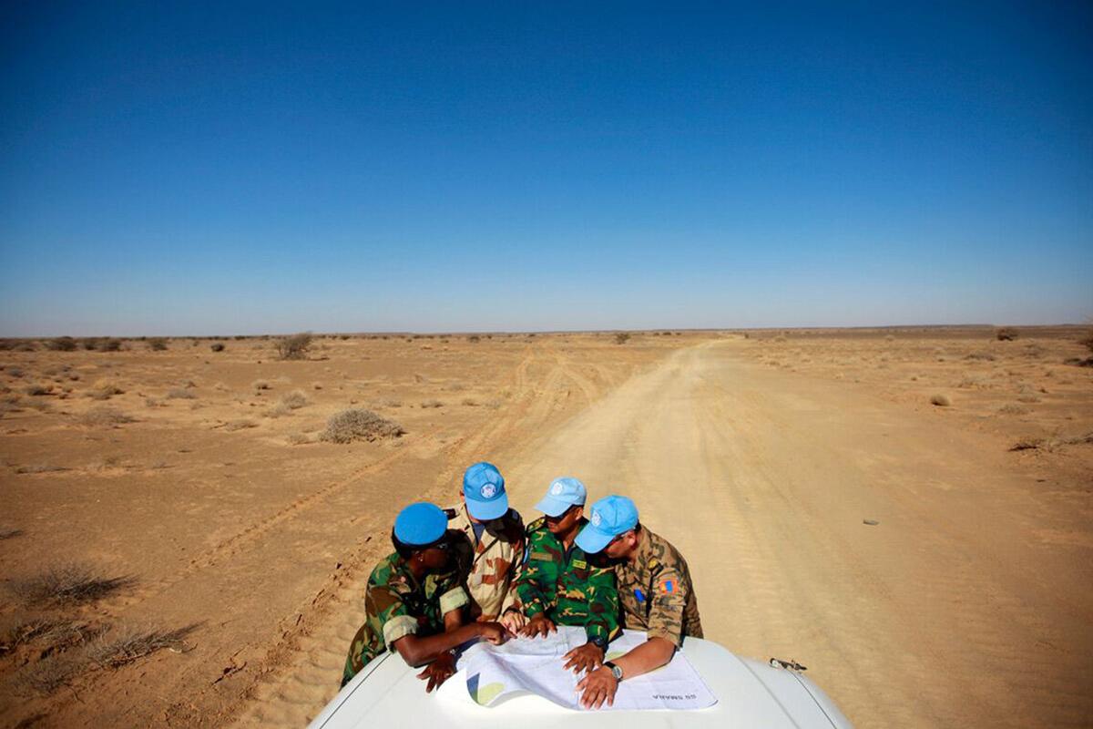 some peacekeepers are discussing on a car