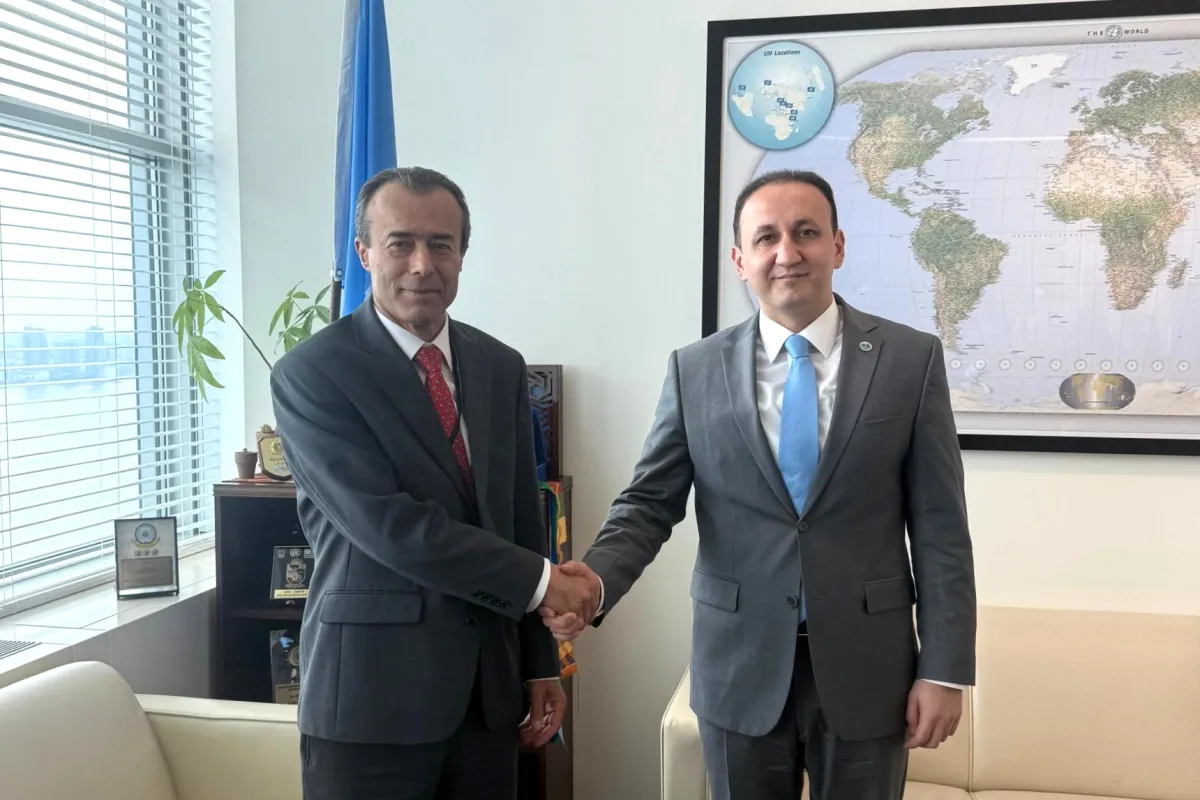 ASG Khaled Khiari and SCO Deputy Secretary-General Ahmad Saidmurodzoda shake hands.