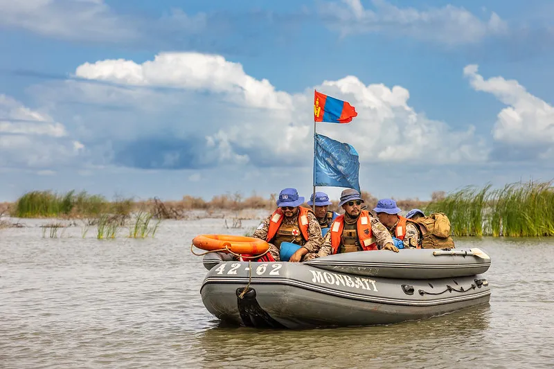 Mongolian peacekeepers conduct a boat patrol through floods to reach remote Tong and engage with communities residing there