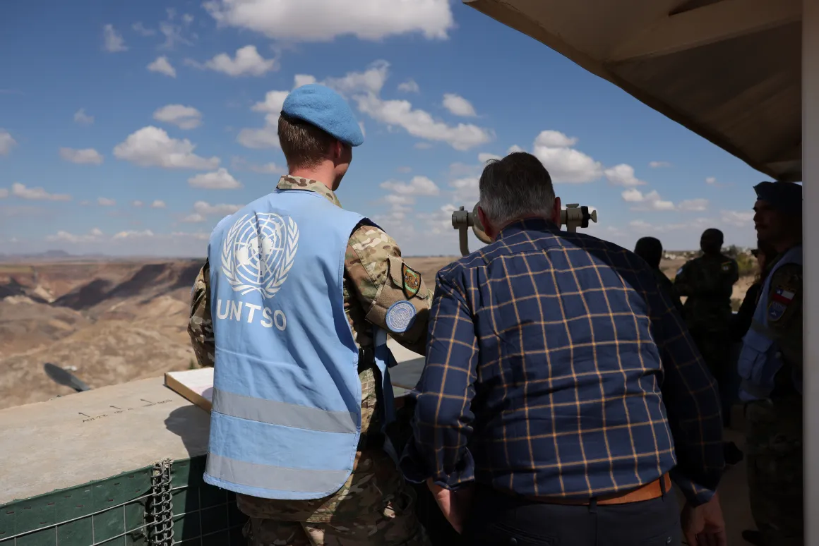 Peacekeeping chief looking through a telescope in the Golan with UNTSO peacekeeper