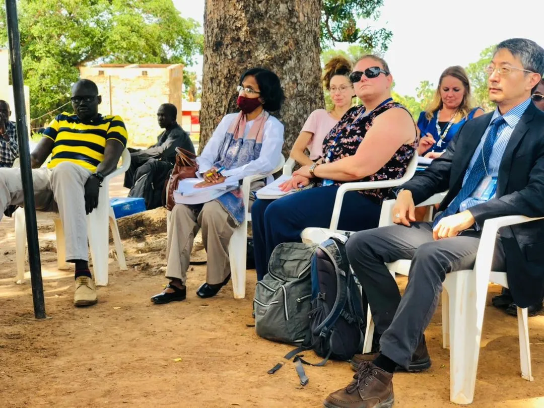 A group of individuals listen to a discussion at a mobile court in South Sudan
