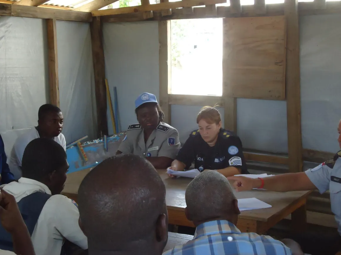 Two women police officers speak with community members