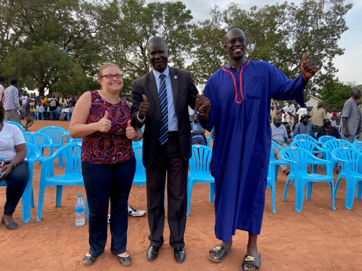 Three judicial officals smile at a mobile court in South Sudan